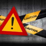 Trump THREATENS Iran’s New Supreme Leader Warning sign with caution tape against a concrete background