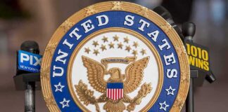 Official seal of the United States Senate with microphones in the background