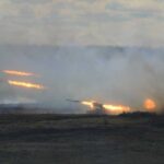 A tank firing in a smoky battlefield during a military exercise