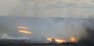 A tank firing in a smoky battlefield during a military exercise