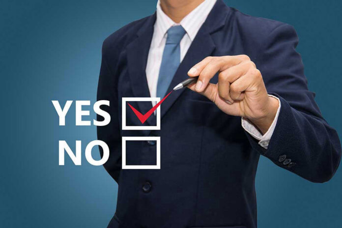 Man in suit selecting yes with pen