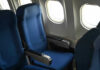 Empty airplane seats next to windows.