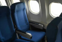 Empty airplane seats next to windows.