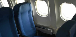 Empty airplane seats next to windows.