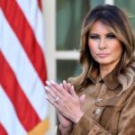 Melania clapping in front of an American flag