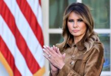 Melania clapping in front of an American flag