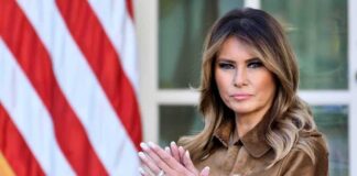 Melania clapping in front of an American flag