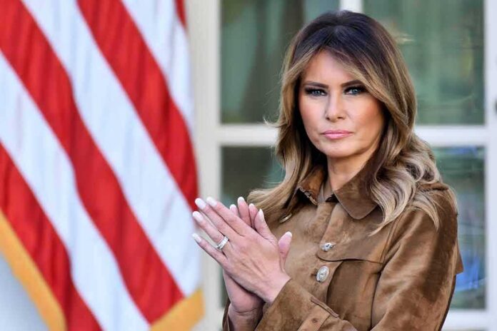 Melania clapping in front of an American flag
