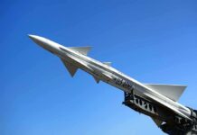 A military missile pointed upwards against a clear blue sky