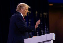 Trump BLASTS ALLY: Political War Erupts! Person speaking at a podium with hand raised