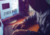 New Cyber Branch Plan Raises Big Questions Hacker typing at desk with Cyber War screen.