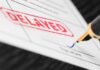 Hunter Biden SCANDAL — Justice Delayed? A close-up of a document with a red 'DELAYED' stamp and a fountain pen poised to sign