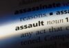 Family Trapped As Carjacker Forces In Close-up of a dictionary page showing the definition of the word 'assault'