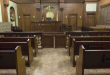 Federal Judge’s Shocker: Voting Rule Stays Interior view of an empty courtroom with wooden benches and a judges bench