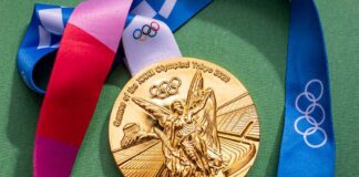 Gold Olympic medal from the Tokyo 2020 Games with a colorful ribbon