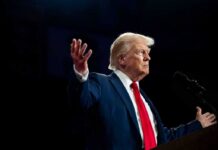 A man in a suit gesturing during a speech
