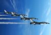 Silent Strikes, Louder Risks Ahead Four military jets flying in formation against a blue sky, leaving smoke trails