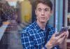 Young man using a smartphone with face recognition overlay