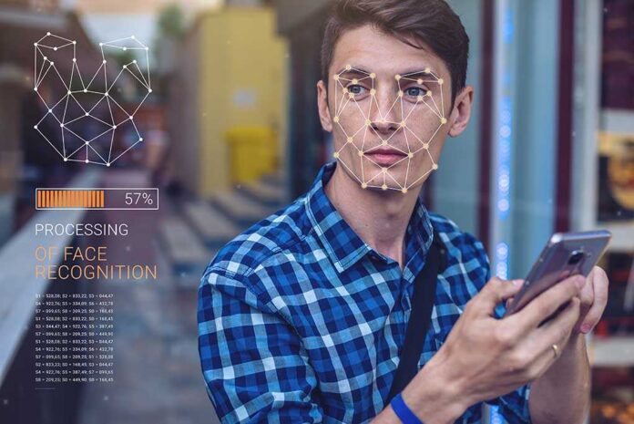 Biometric,Verification.,Modern,Young,Man,With,The,Phone.,The,Concept Young man using a smartphone with face recognition overlay