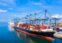 Deal Announced, But Maritime Traffic Remains Frozen Container ship docked at a busy industrial port.