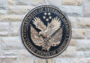 VA Tinnitus Ratings Could Be Slashed Under New Bill Department of Veterans Affairs seal on brick wall.