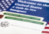 Federal Lawsuit Hits Virginia Over Mask Rule for Immigration Agents Permanent resident cards with welcome guide and flag.