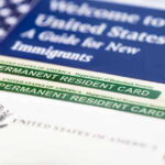 Federal Lawsuit Hits Virginia Over Mask Rule for Immigration Agents Permanent resident cards with welcome guide and flag.