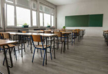 Convicted Teacher Fuels Locker-Room Allegations Empty classroom with desks, chairs, windows, and chalkboard.