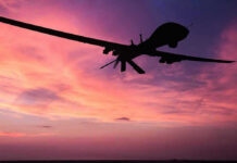US Strike Claim on Gang Boss Awaiting Verification Silhouette of a drone against a colorful sunset.