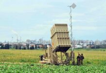 Military defense system deployed in a field with soldiers nearby