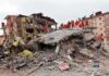 Twin Earthquakes: Hundreds Dead, Thousands Still Trapped, Toll Still Rising Rescue workers in orange uniforms on a collapsed building site after an earthquake