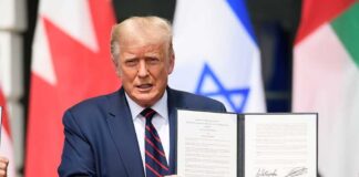 A man holding a signed document during a diplomatic event