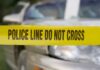 Gunfire Erupts Near Toledo Festival, 12 Shot Yellow police tape reading POLICE LINE DO NOT CROSS in front of a vehicle