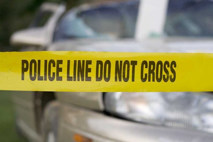 Yellow police tape reading POLICE LINE DO NOT CROSS in front of a vehicle