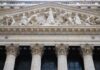 Facade of the New York Stock Exchange featuring classical columns and sculptures