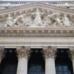 Facade of the New York Stock Exchange featuring classical columns and sculptures