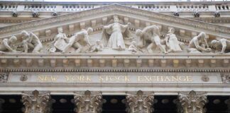Facade of the New York Stock Exchange featuring classical columns and sculptures