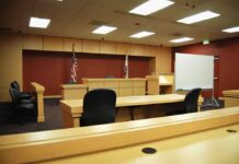 Surveillance Shows Freezer Move After Woman Vanishes Interior view of an empty courtroom with wooden furniture and American flags