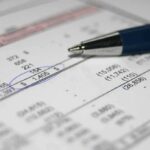 California Wealth Tax Sparks Backlash as Newsom Warns It Could Backfire Close-up of a financial document with highlighted numbers and a pen