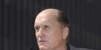 A man speaking into a microphone at an outdoor event