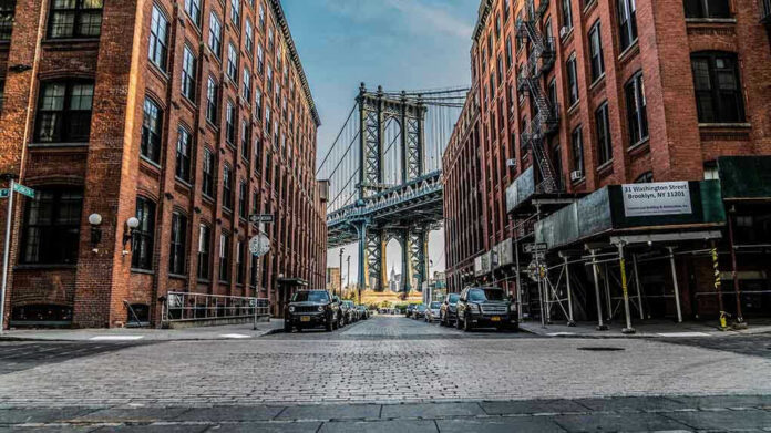 1071270287 Street view with bridge between two brick buildings.