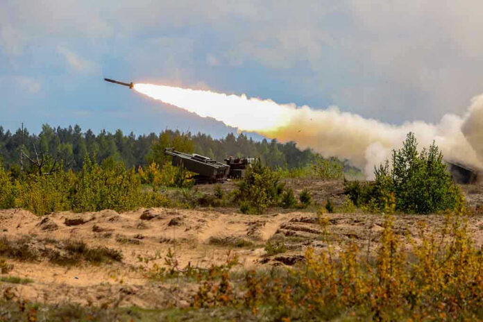 1302196150 Military tank firing a missile in forest area.