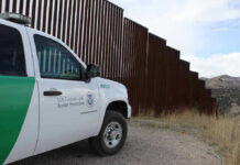 Court Records and Family Claims Raise Border protection vehicle near a large metal fence.