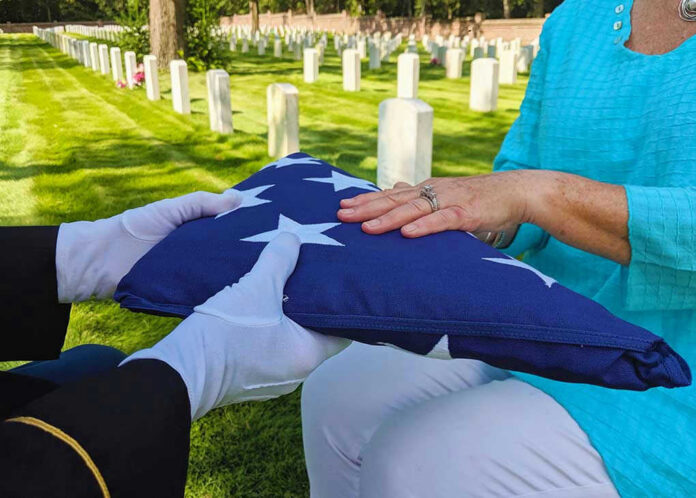 1575982354 Flag folded and handed over at gravesite ceremony.
