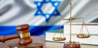 Gavel and scales of justice with Israeli flag in background