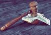 Judge's gavel resting on a stack of US dollar bills