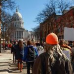 Crowd of protesters walking toward a domed capitol building