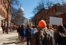Crowd of protesters walking toward a domed capitol building