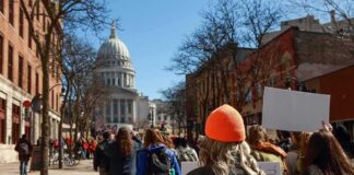 Crowd of protesters walking toward a domed capitol building