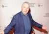 man in blue blazer posing at a film festival step-and-repeat